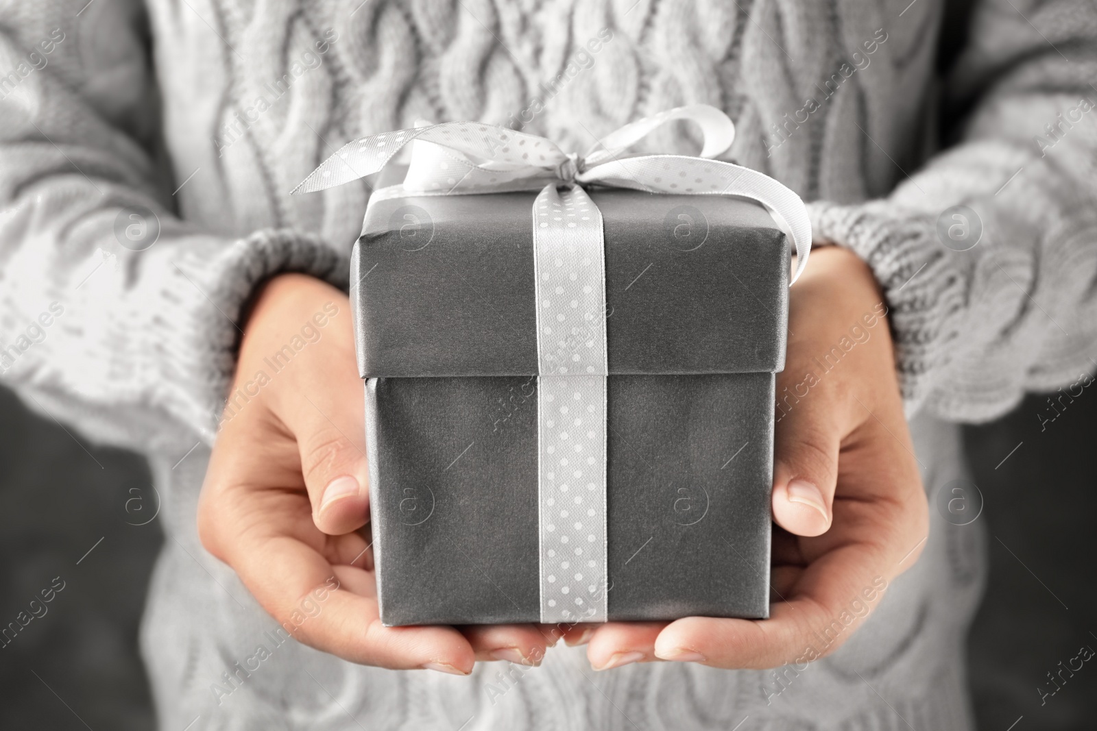 Photo of Woman holding beautiful Christmas gift with bow, closeup