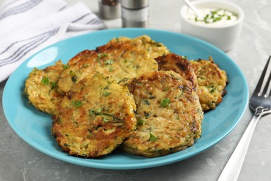 Photo of Delicious zucchini pancakes served on grey table, closeup