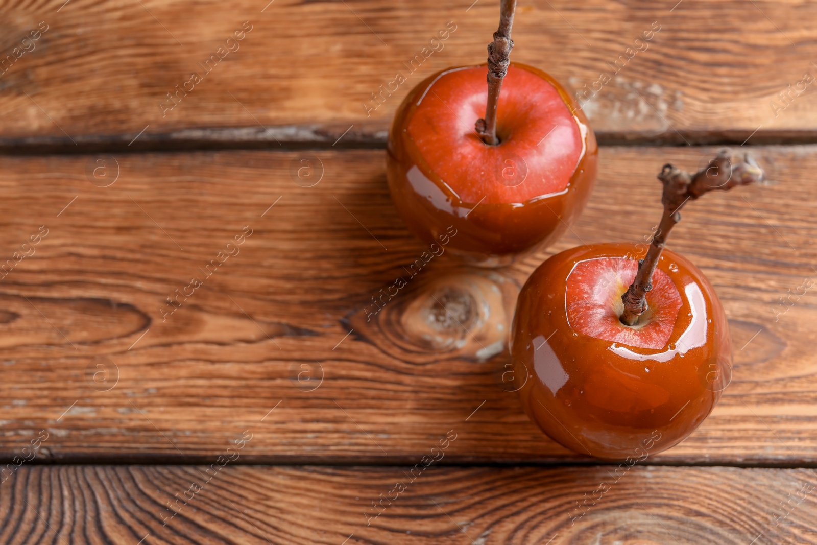 Photo of Delicious red caramel apples on table