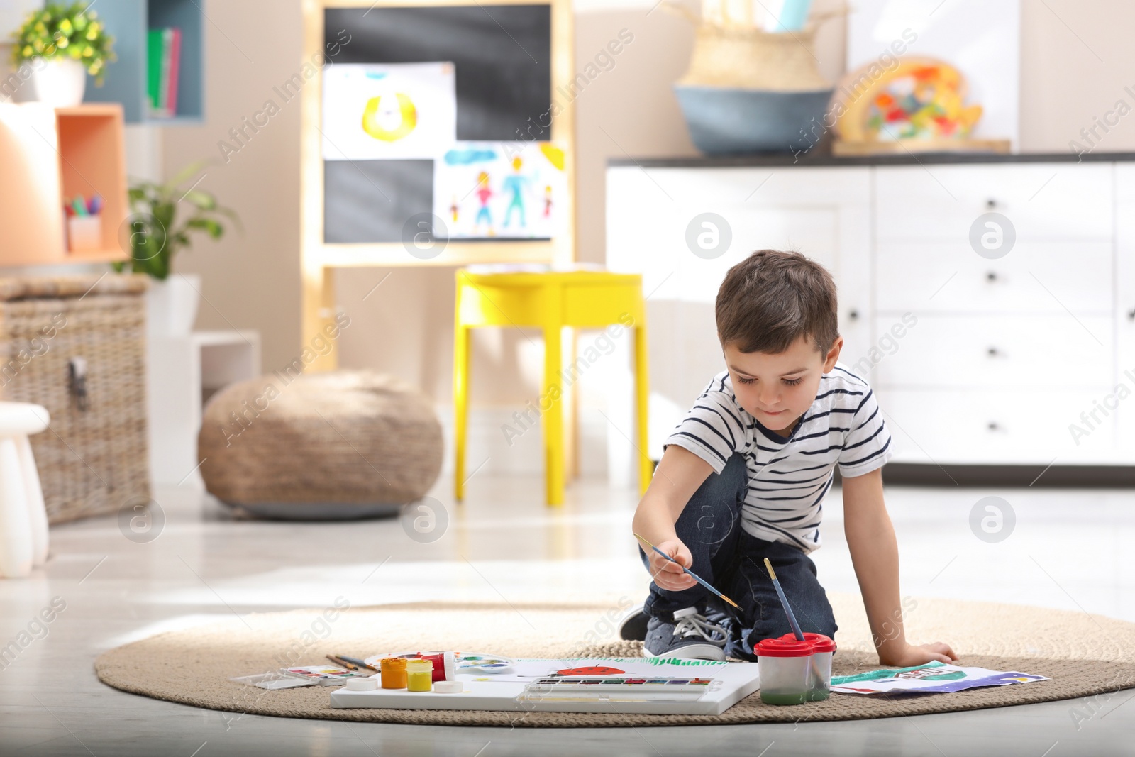 Photo of Little child painting on floor at home