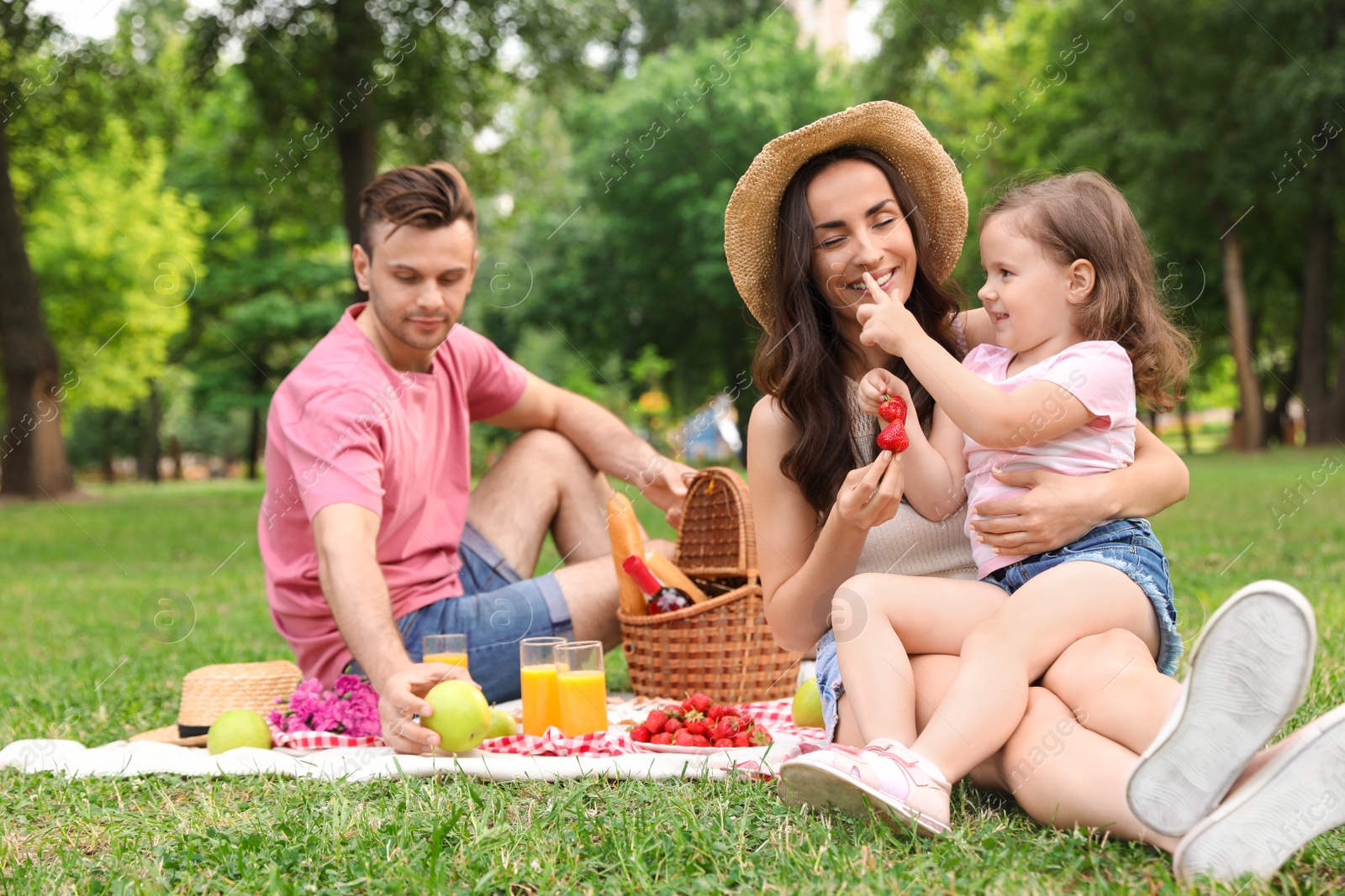 Photo of Happy family having picnic in park on summer day