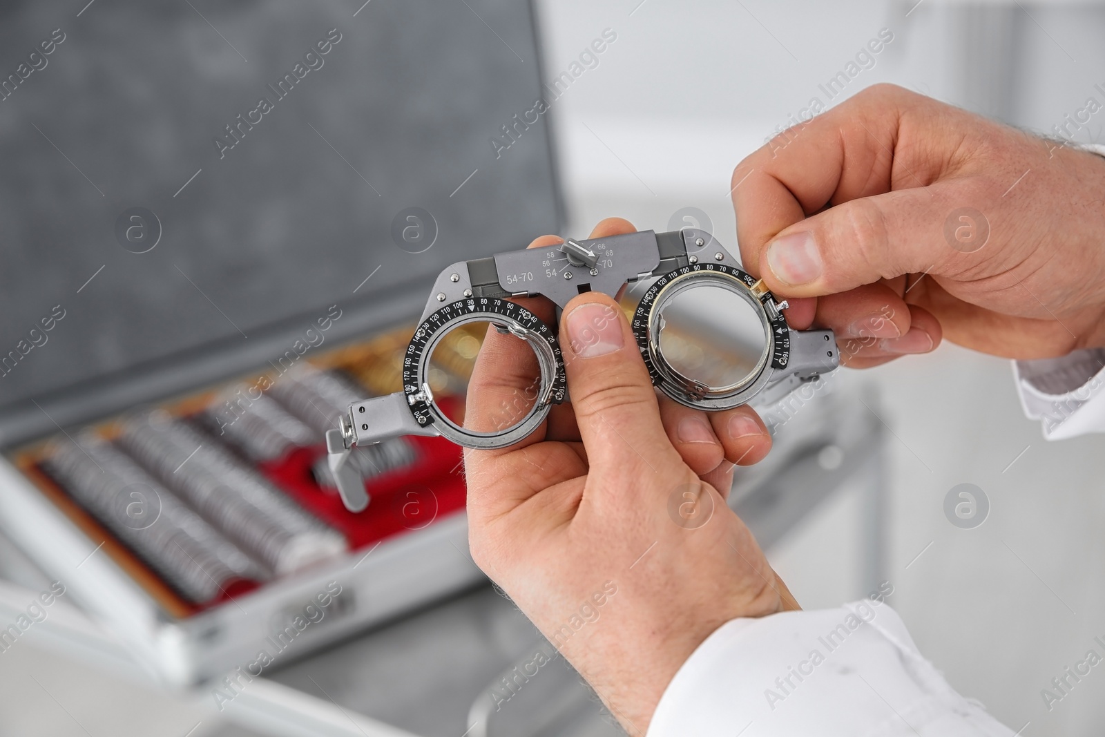 Photo of Children doctor holding trial frame and lens on blurred background, closeup