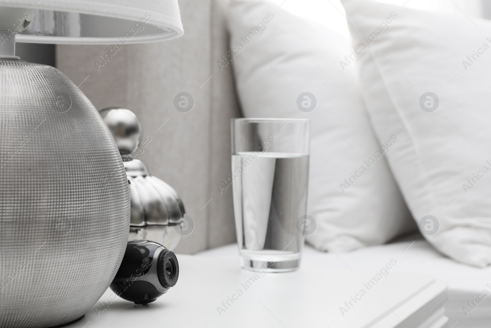 Photo of Small hidden camera on white nightstand in bedroom