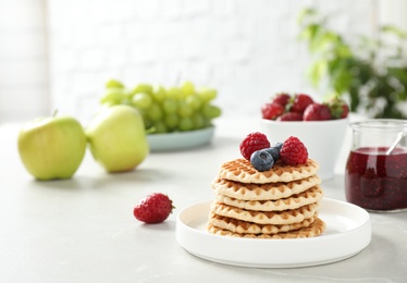 Delicious breakfast with waffles and berries on light table. Space for text