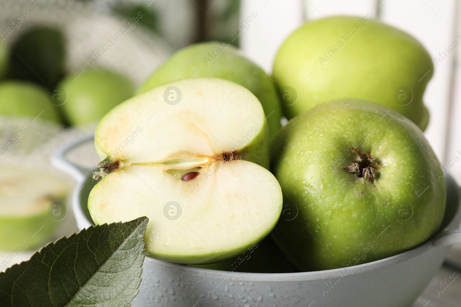 Photo of Fresh green apples with water drops in colander, closeup