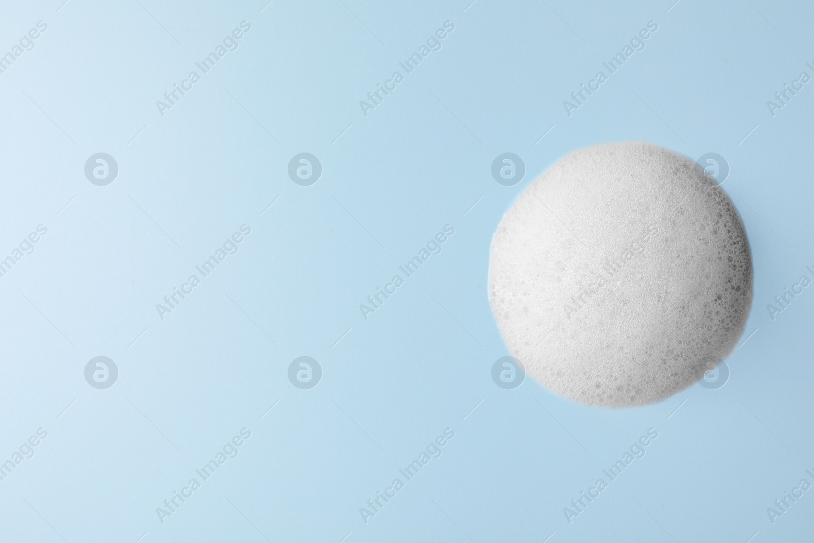 Photo of Foam sample on light blue background, top view. Space for text