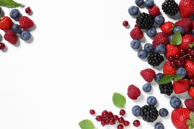 Many different fresh berries and mint leaves on white background, flat lay. Space for text