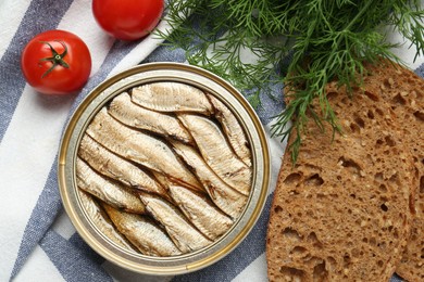 Photo of Canned sprats, dill, tomatoes and bread on table, flat lay