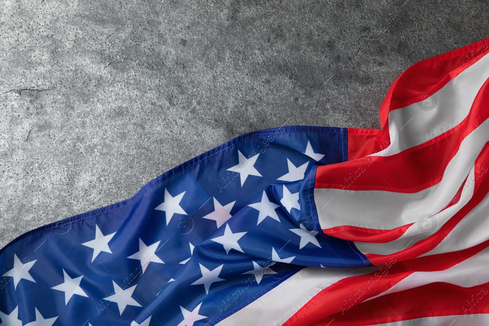 Photo of American flag on grey table, top view with space for text. Memorial Day