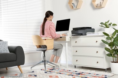 Photo of Woman using modern printer at workplace indoors