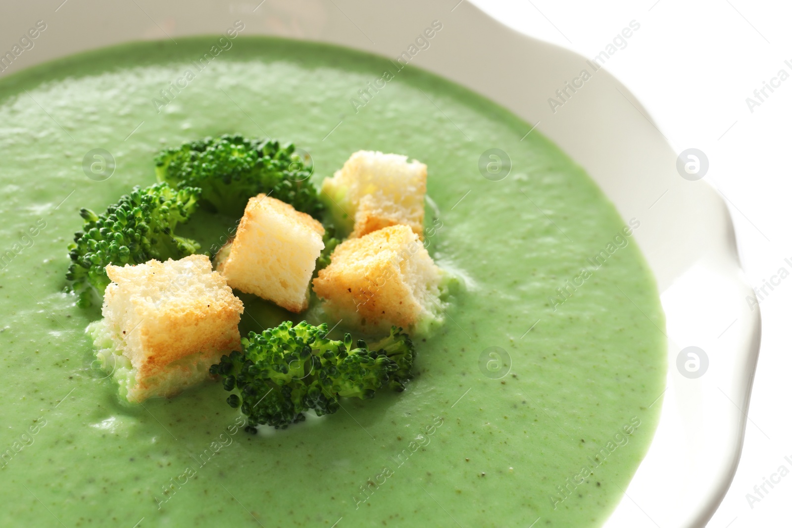 Photo of Fresh vegetable detox soup made of broccoli with croutons in dish, closeup