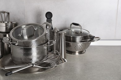 Set of different cooking utensils on grey countertop in kitchen