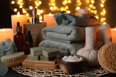 Beautiful composition with different spa products on table against blurred lights