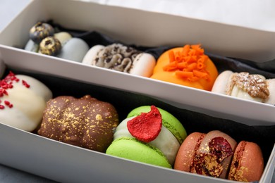 Photo of Cardboard box with delicious sweet macarons, closeup