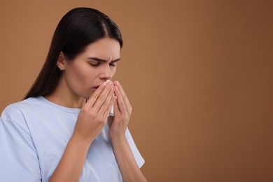 Photo of Woman with tissue coughing on brown background, space for text. Cold symptoms