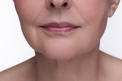 Photo of Senior woman with aging skin on white background, closeup. Rejuvenation treatment