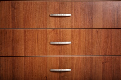 Photo of Wooden wardrobe drawers as background, closeup view