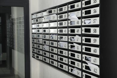 New mailboxes with keyholes, numbers and receipts near entrance in post office