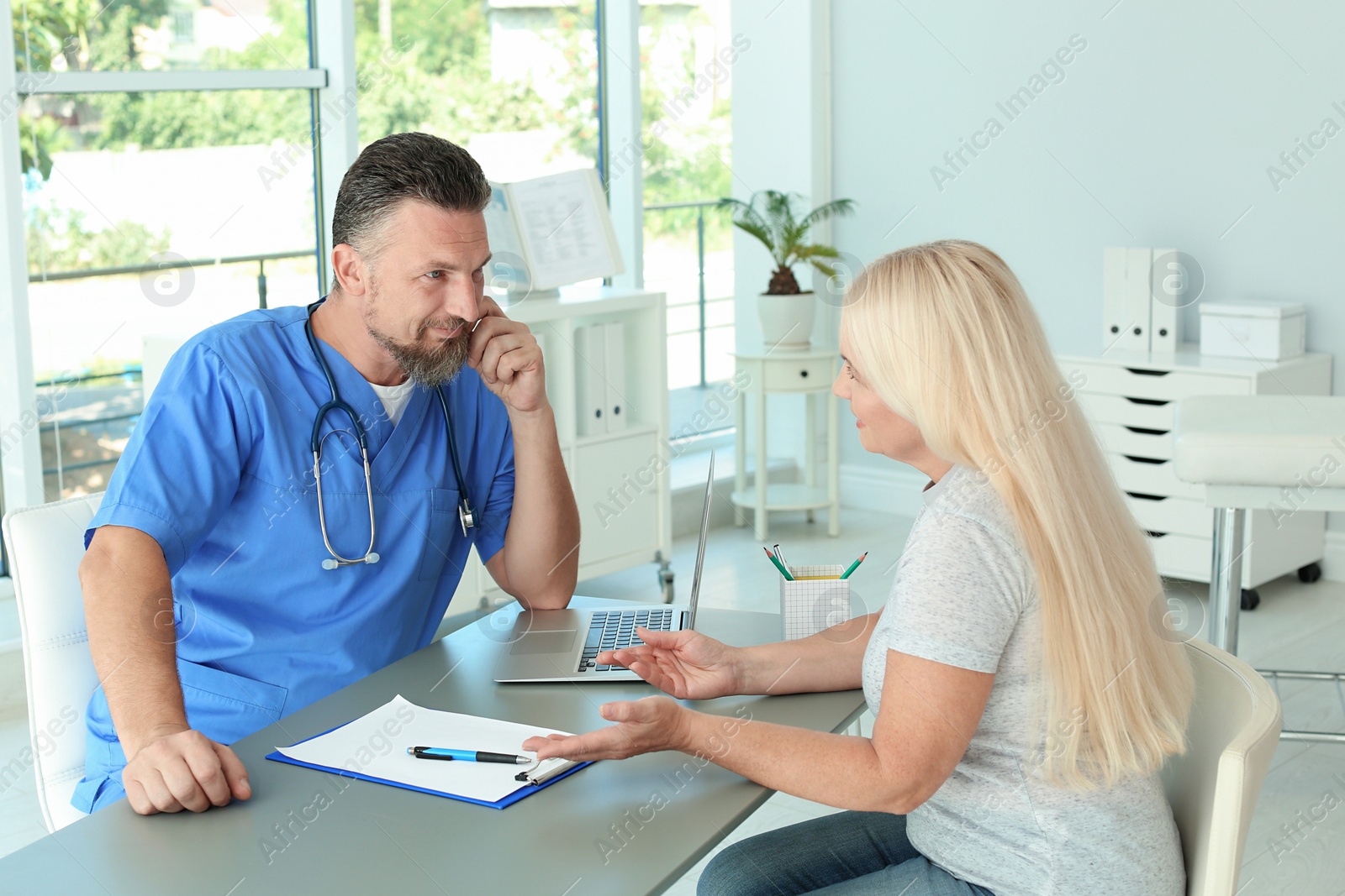 Photo of Male medical assistant consulting female patient in clinic