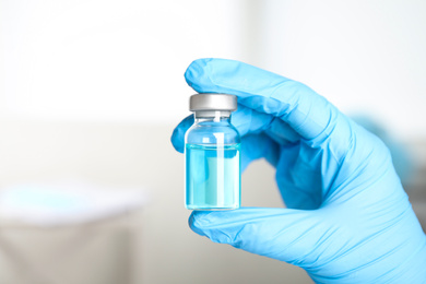 Doctor holding vial with medication, closeup. Vaccination and immunization
