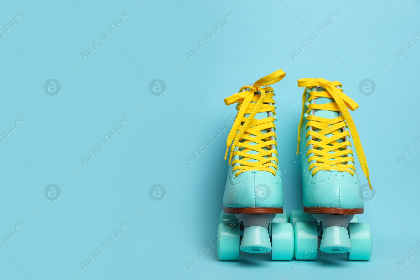 Photo of Pair of stylish quad roller skates on color background. Space for text