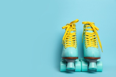 Photo of Pair of stylish quad roller skates on color background. Space for text