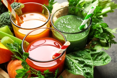 Photo of Delicious vegetable juices and fresh ingredients on table, closeup view