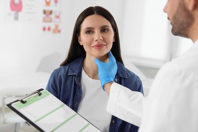 Endocrinologist examining thyroid gland of patient at hospital, closeup