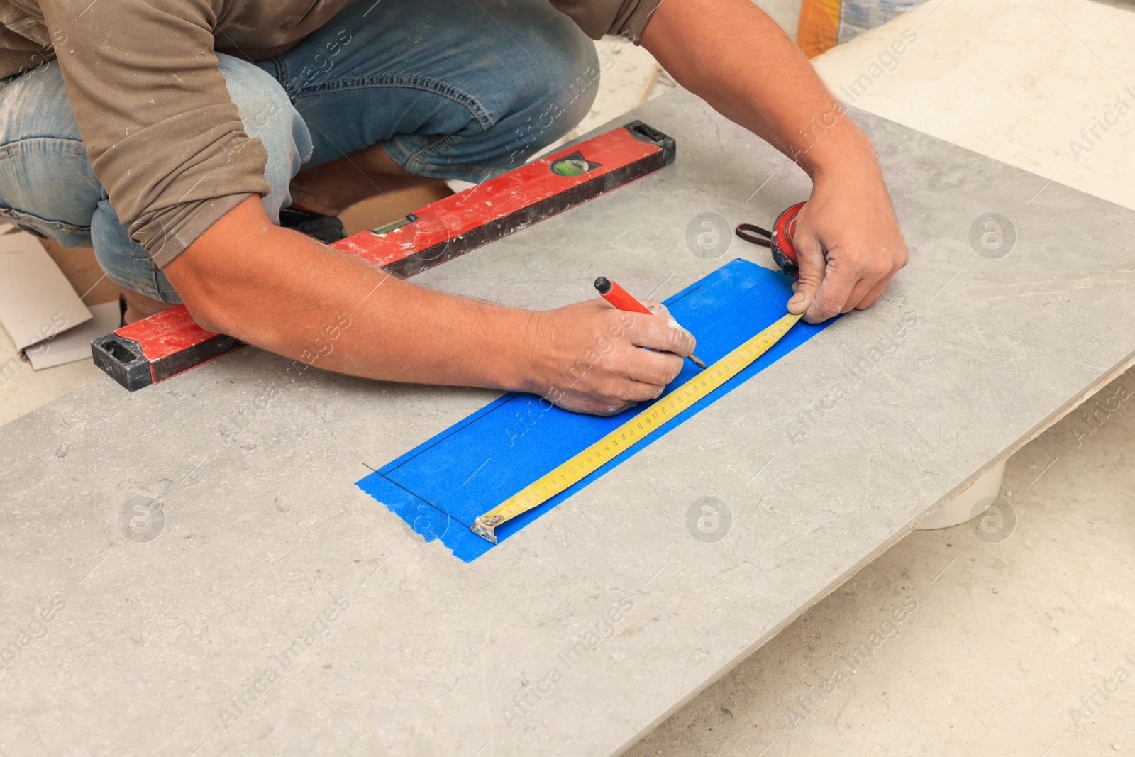 Photo of Worker making socket hole in tile indoors, closeup