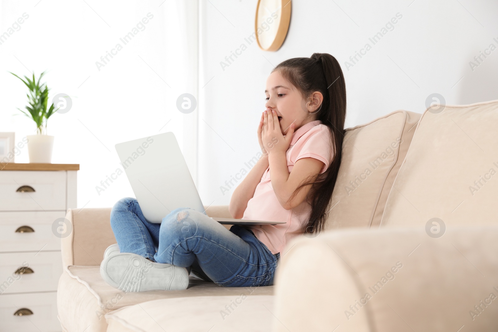 Photo of Little girl using video chat on laptop at home