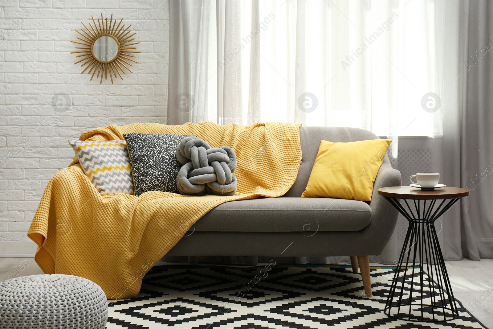 Photo of Stylish living room interior with soft pillows and yellow plaid on sofa