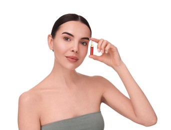 Beautiful young woman holding skincare ampoule on white background