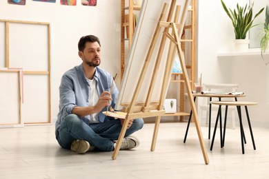 Photo of Handsome man painting in studio. Creative hobby