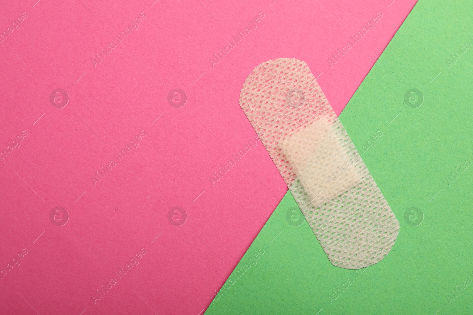 Photo of Sticking plaster on color background, top view. Space for text