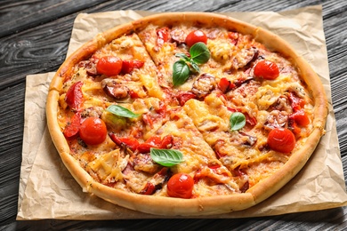 Photo of Delicious pizza with tomatoes and sausages on table