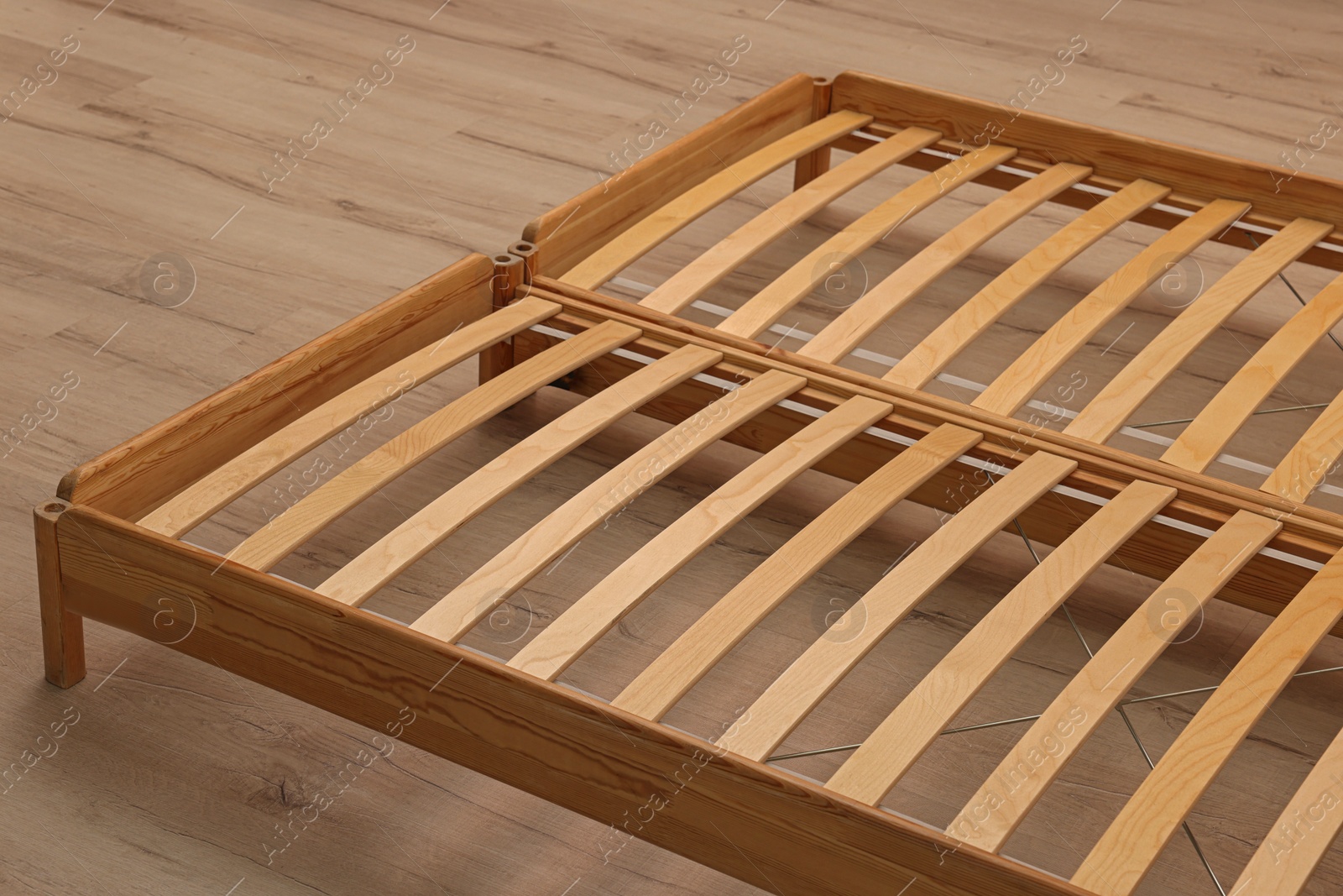 Photo of Wooden bed frame on floor, closeup view