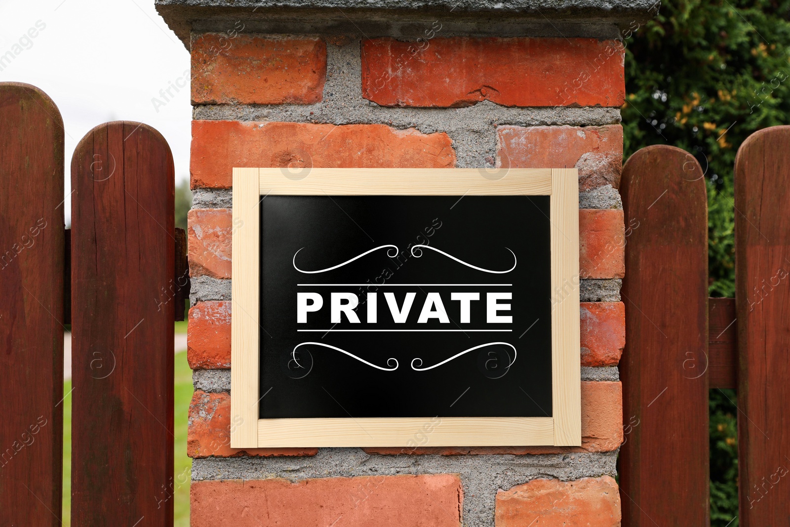 Image of Sign with word Private on brick column of wooden fence