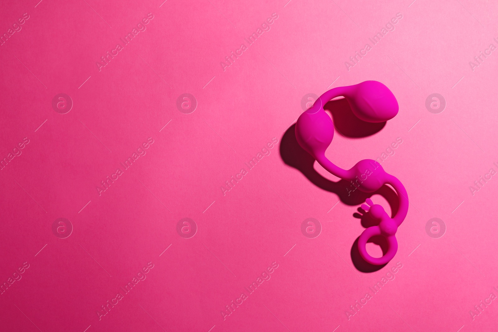 Photo of Anal balls on pink background, top view with space for text. Sex toy