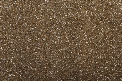 Photo of Shiny light brown glitter as background, closeup