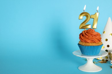 Photo of Delicious cupcake with number shaped candles on color background, space for text. Coming of age party - 21th birthday
