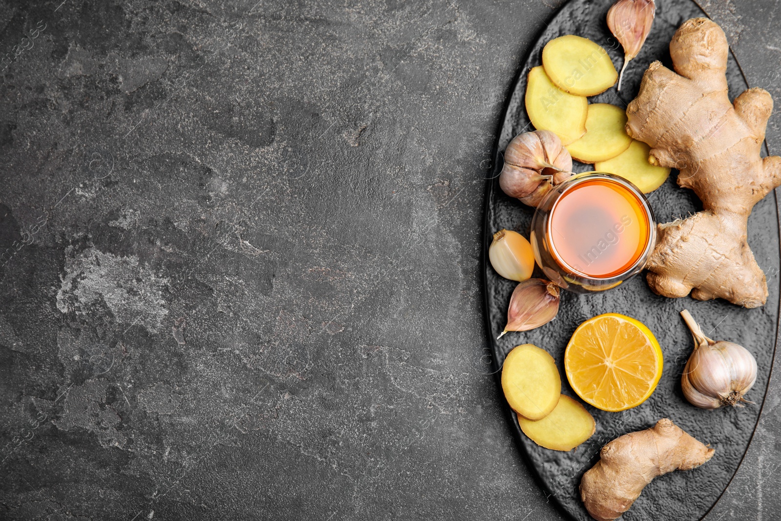 Photo of Fresh garlic and other natural cold remedies on grey table, top view. Space for text