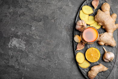 Photo of Fresh garlic and other natural cold remedies on grey table, top view. Space for text