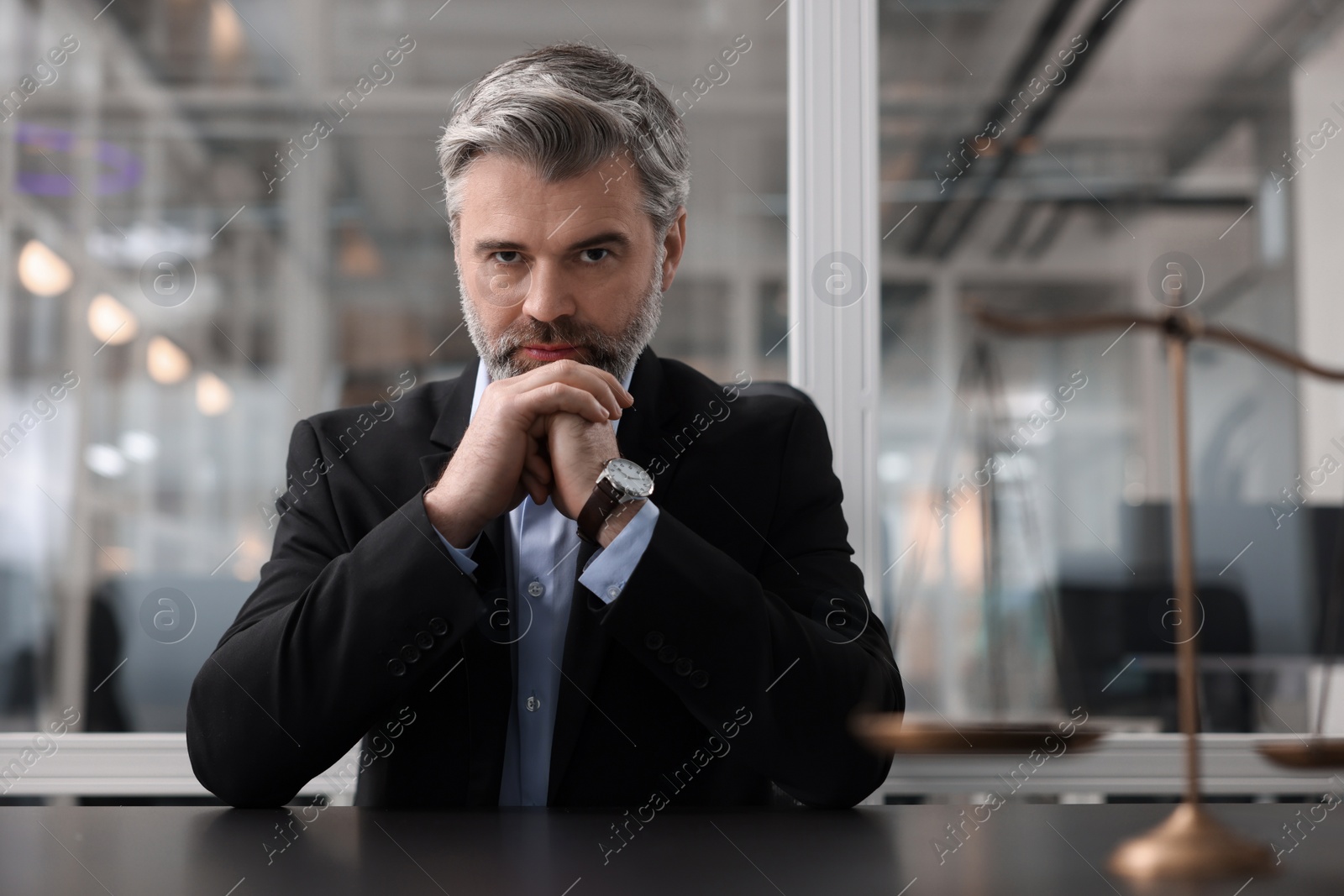 Photo of Portrait of confident lawyer at table in office