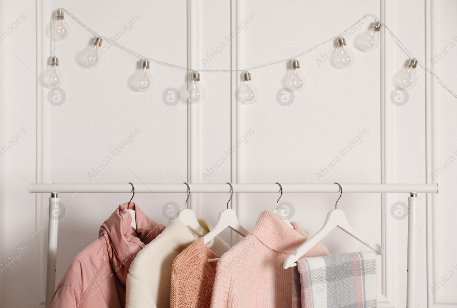 Photo of Rack with stylish warm clothes indoors, closeup