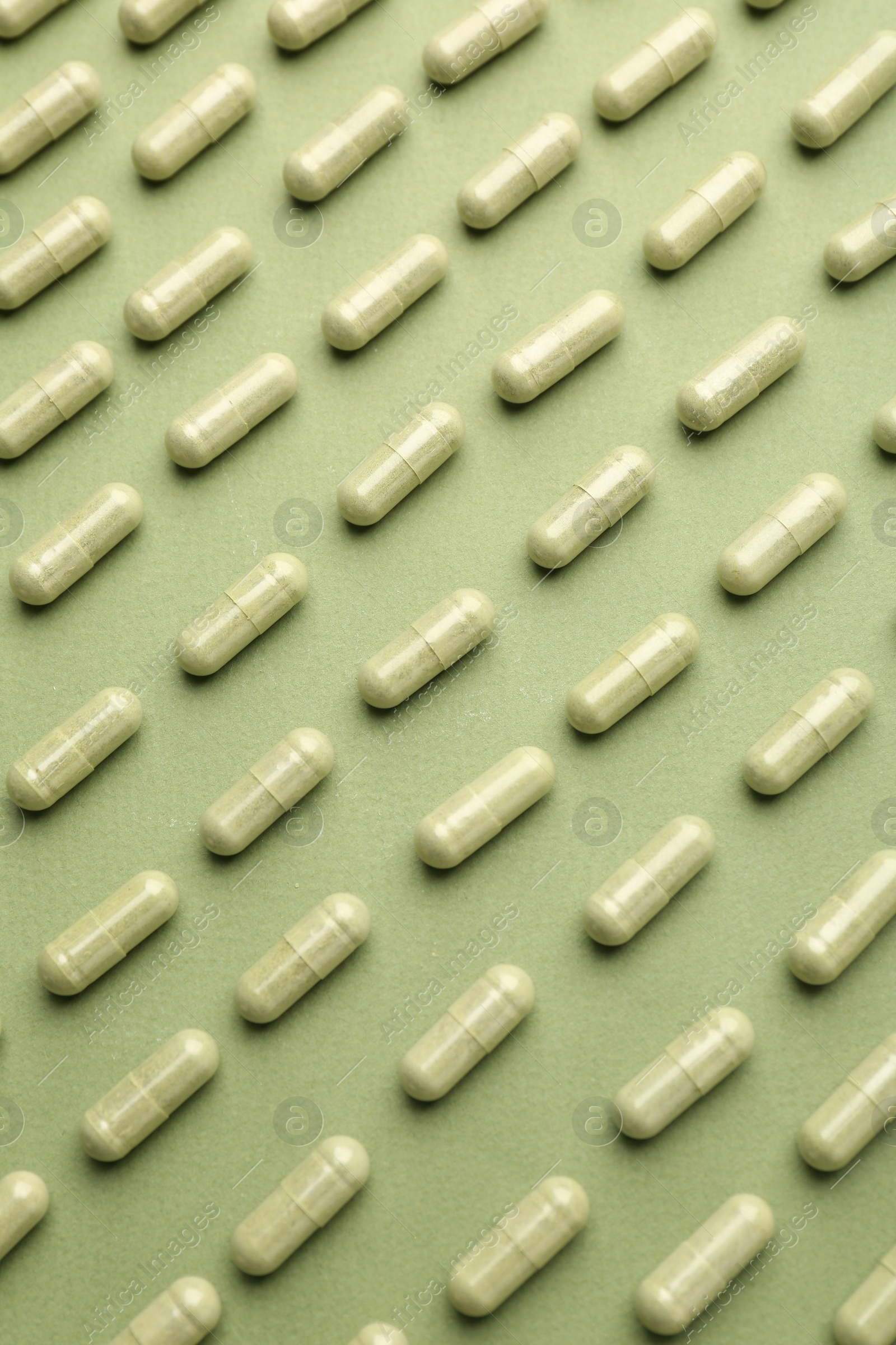 Photo of Vitamin capsules on olive background, flat lay