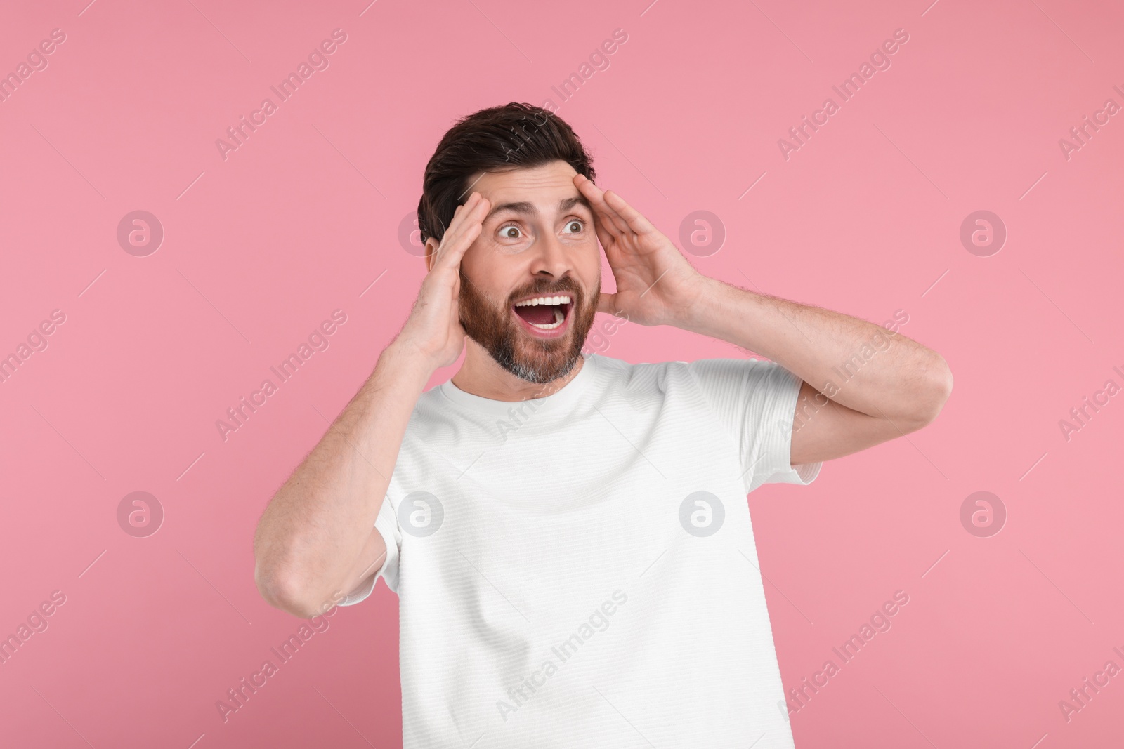 Photo of Portrait of surprised man on pink background