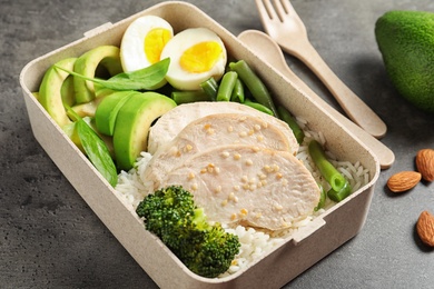 Photo of Container with natural protein food on gray table