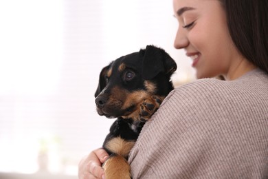 Photo of Woman with cute puppy on light background. Lovely pet