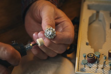 Photo of Professional jeweler working with gemstones at table, above view