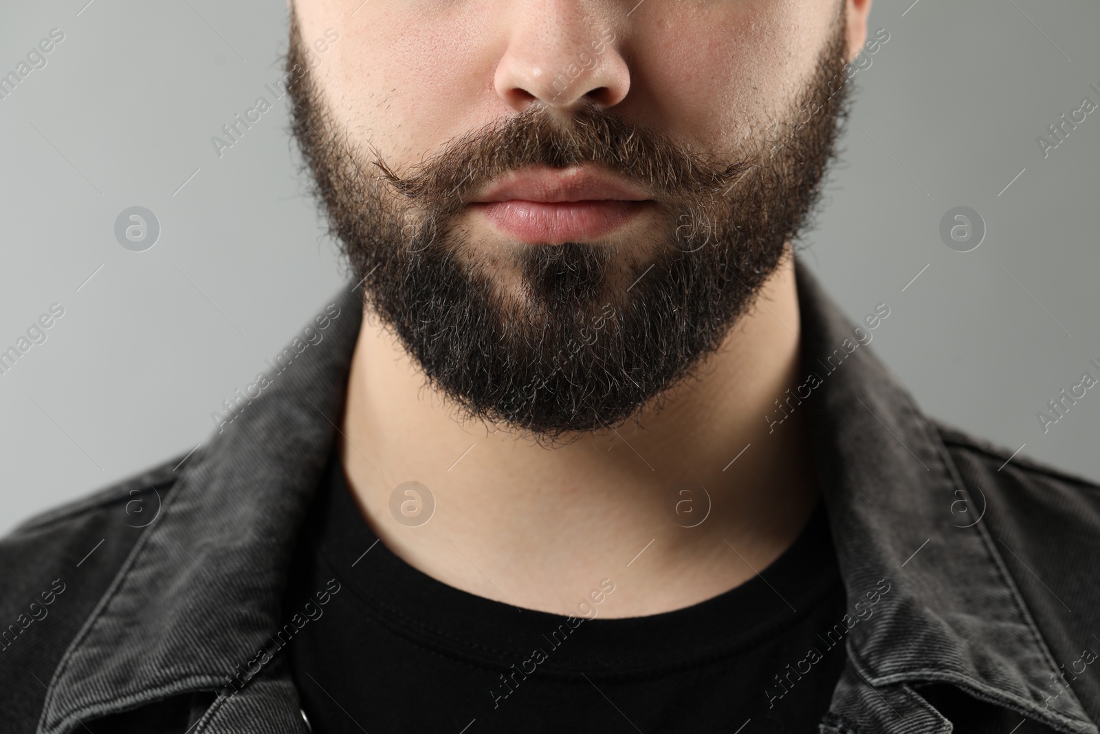 Photo of Handsome young man with mustache on grey background, closeup